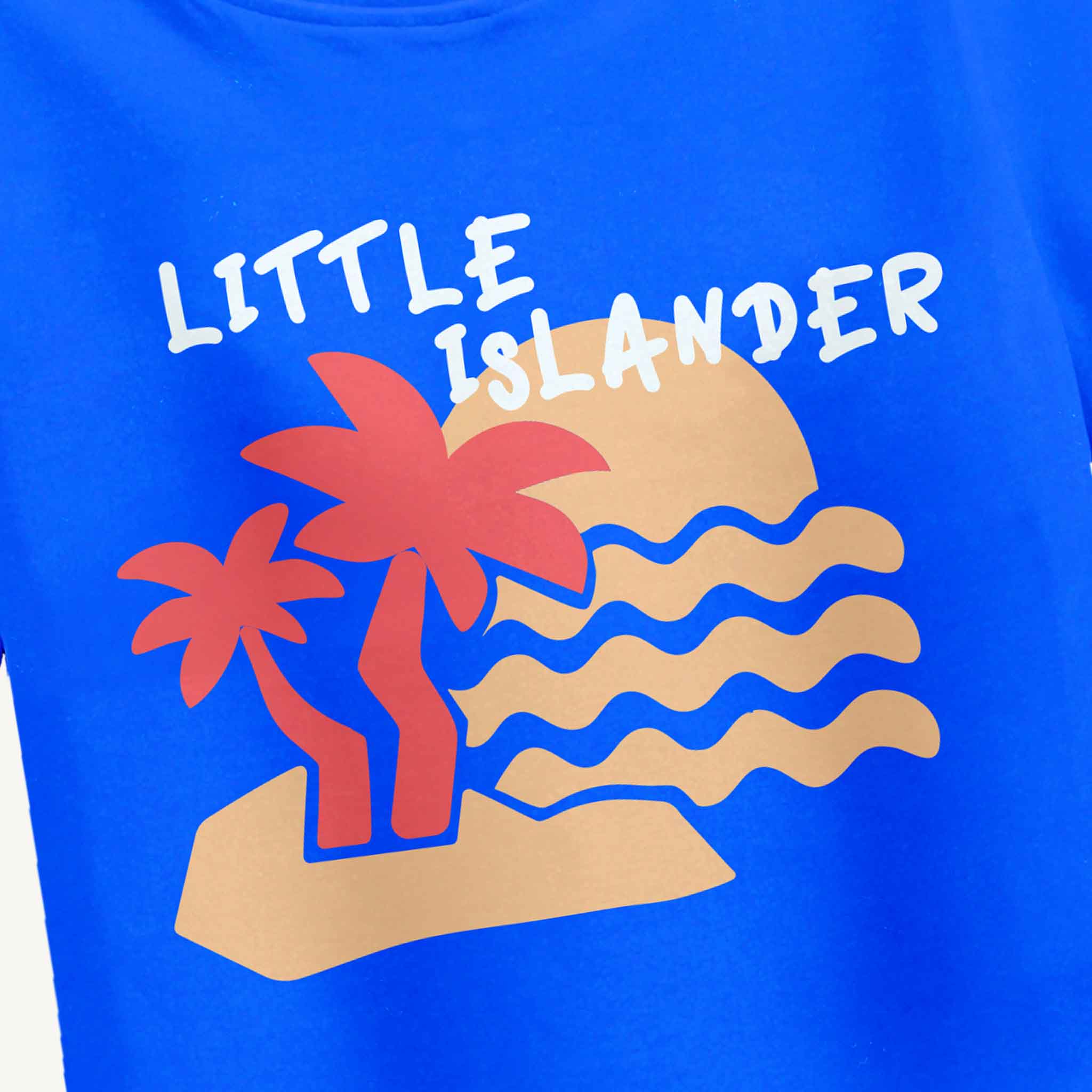 Blue t-shirt with 'Little Islander' graphic featuring palm trees and waves.