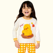Child wearing a pajama set with a chick design on a white background