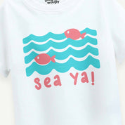 White shirt with blue waves and pink fish design, featuring the text 'sea ya!'.