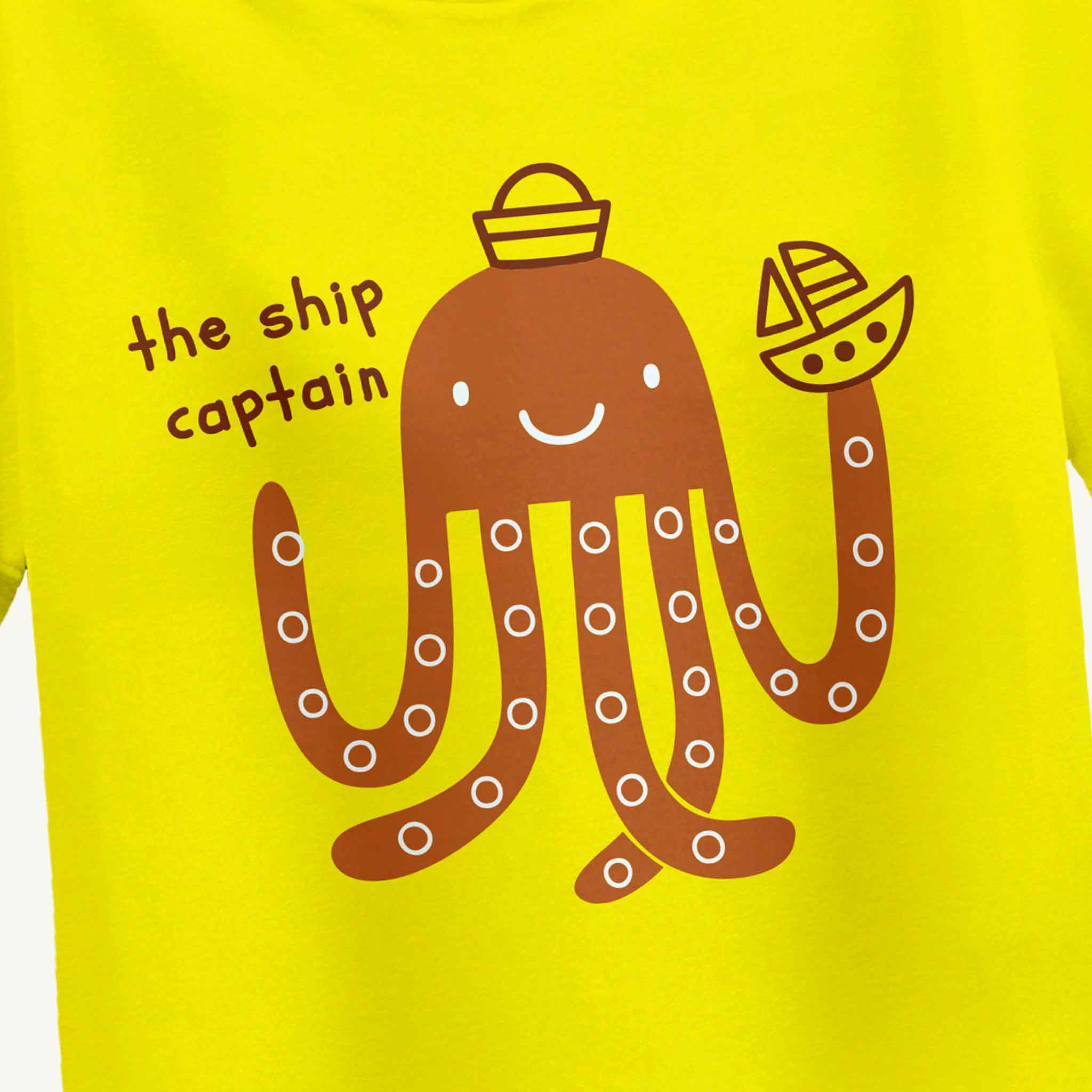 Yellow t-shirt with a brown octopus design and text 'the ship captain' on a yellow background.
