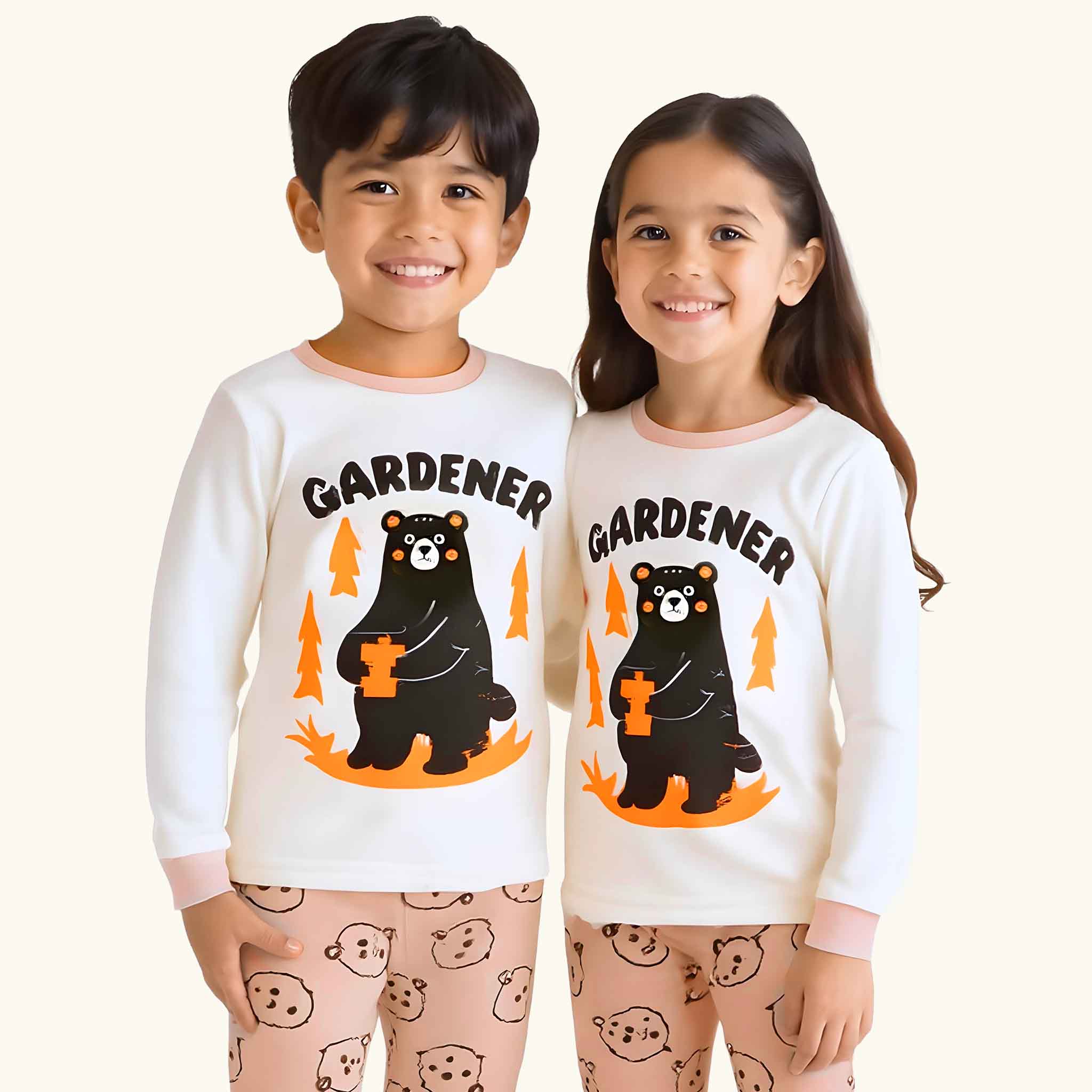 Two children wearing matching 'Gardener'-themed pajamas with bear graphics on a plain background.