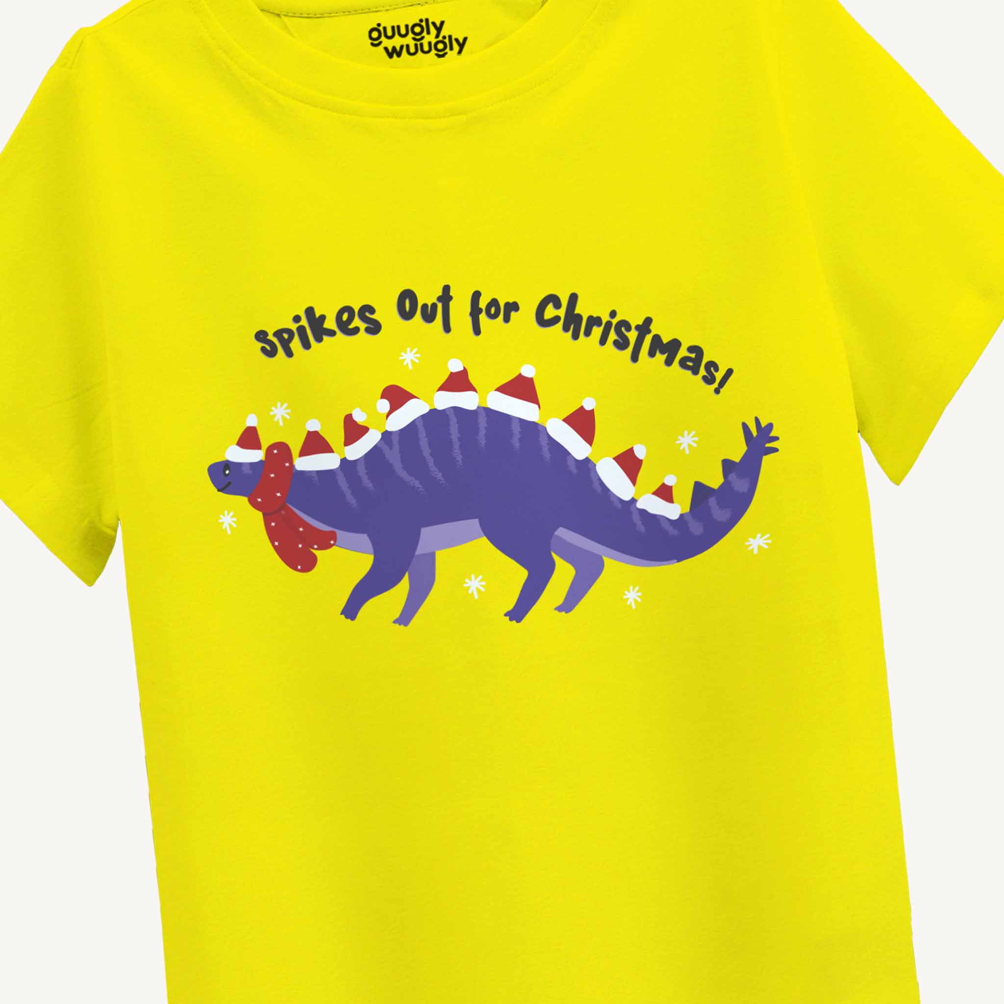 Yellow t-shirt with a purple dinosaur wearing Santa hats and text 'Spikes Out for Christmas!' on a white background.