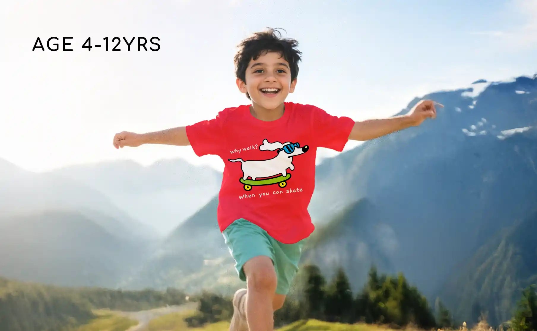 Child wearing a red shirt with a dog graphic, running outdoors with mountains in the background