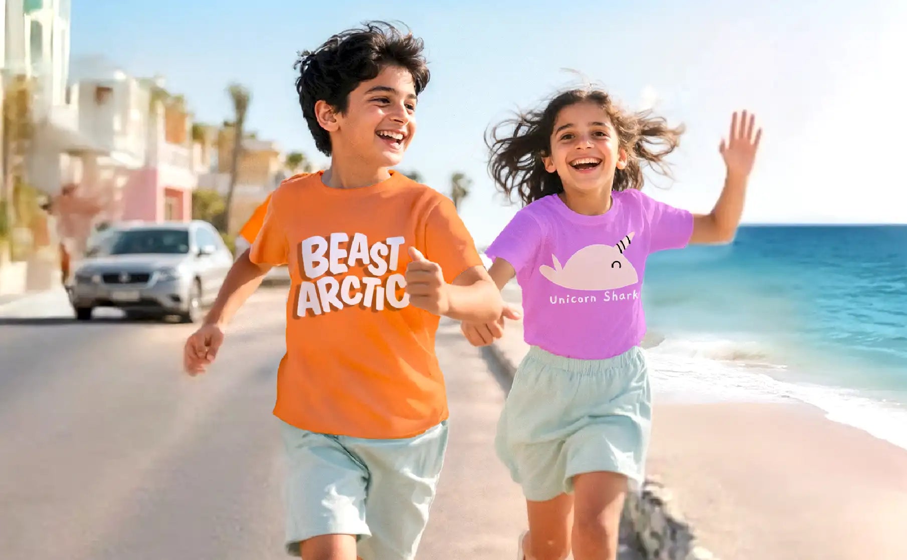Two children running on a beach with a clear blue sky.