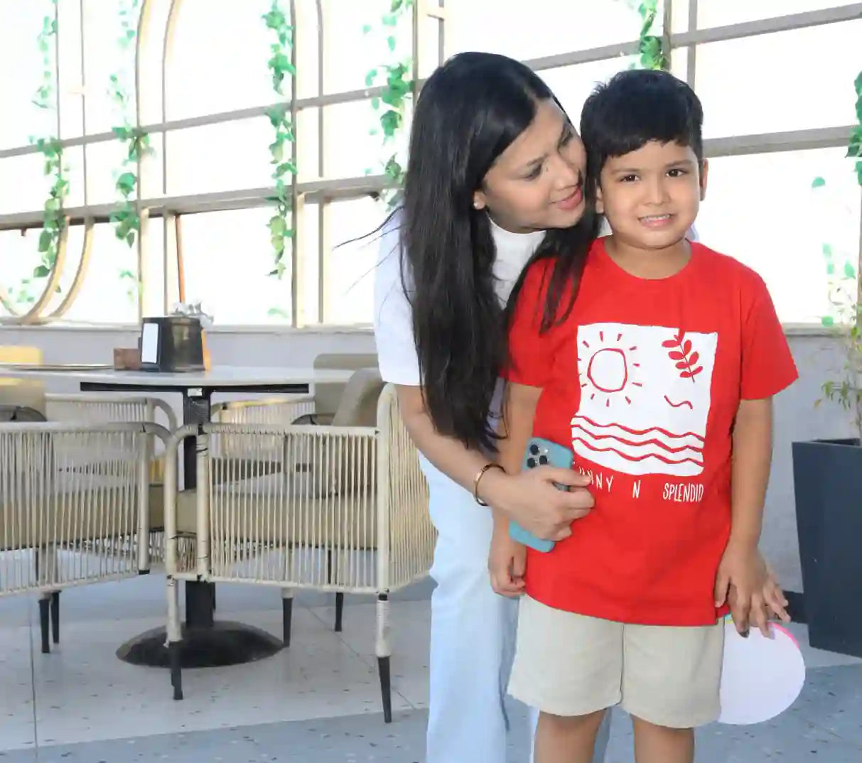 Woman and child standing together in an indoor setting with a modern interior design.
